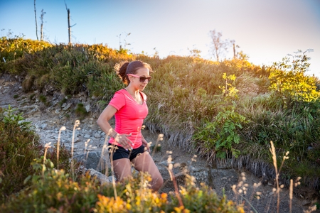 Beautiful young woman running in mountains. Woman trail runner. Szczyrk, Beskidy Mountains, Polandの写真素材