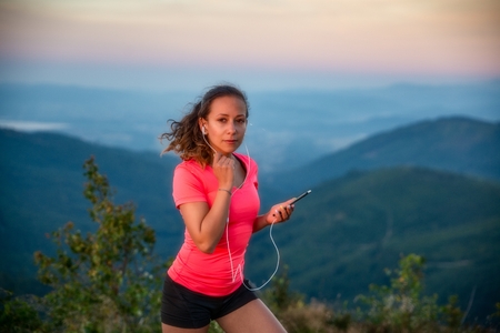 Young woman listening to the music during trail running in mountains. Szczyrk, Beskidy Mountains, Silesian Beskid, Polandの写真素材