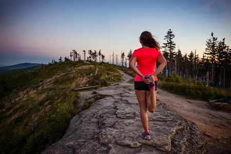 Young woman stretching after trail cross country running in mountains. Polish silesian Beskid, Szczyrk, Polandの写真素材