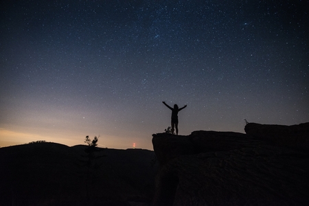 Woman standing at mountain top at starry night. Polish Silesian Beskid, Szczyrk, Polandの写真素材