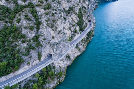Aerial drone view on road and tunnels over Lake Garda in Italy, Limone sul Gardaの写真素材