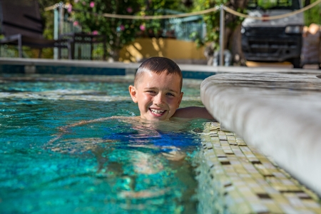 Happy boy child playing in pool, summer vacationsの写真素材