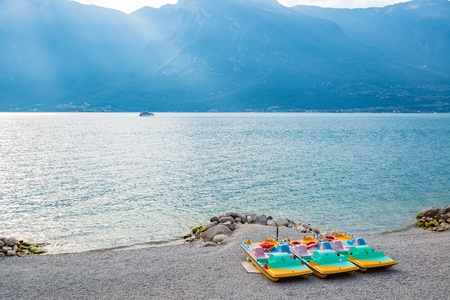Pedal boat on the beach over Lake Garda in Limone sul Garda, Lombardy, Italyの写真素材