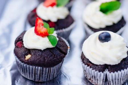 Sweet delicious dark muffin cupcakes with white whipped creamの写真素材