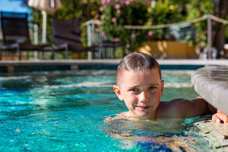 Happy boy child playing in pool, summer vacationsの写真素材