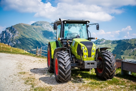 Green tractor on farm in Italian Alps mountainsの写真素材
