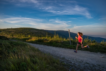 Woman running outdoors. Young woman cross running in the mountains.の写真素材