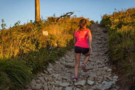 Girl trail running. Young woman cross running in the mountains.の写真素材