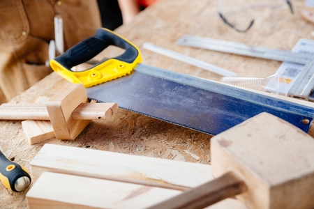 Carpenter's hand saw and tools on wooden table. Renovation, construction conceptの写真素材