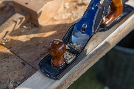 Wood shaving plane on plank. Renovation, construction conceptの写真素材