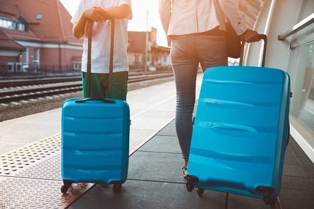 Woman with her son with baggage on train station or airport. Family tripの写真素材
