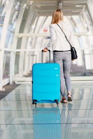 Woman with her baggage on airport terminal. Business tripの写真素材