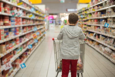 Child with shopping cart in supermarket storeの写真素材