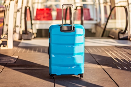 Blue suitcase baggage on escalator on airport or train stationの写真素材