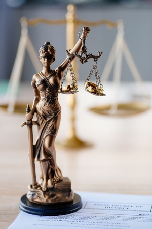 Divorce and family law. Statue of justice and broken wedding rings. Divorce and separation conceptの写真素材