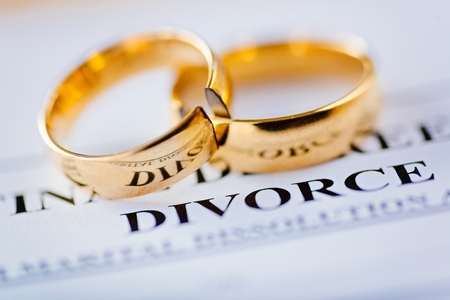 Two broken golden wedding rings divorce decree document. Divorce and separation conceptの写真素材