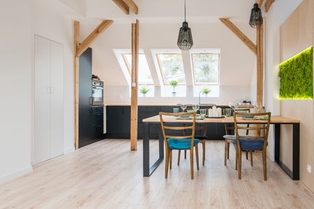 Open bright kitchen with black kitchen cabinets and table. Modern bright flat apartment in the attic. Kitchen with black kitchen cabinetsの写真素材