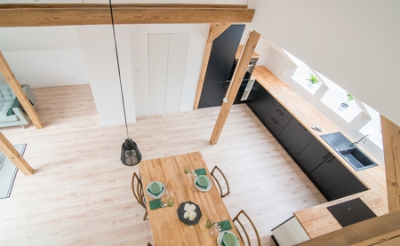 Top view on set wooden dining table. Modern bright flat apartment in the atticの写真素材