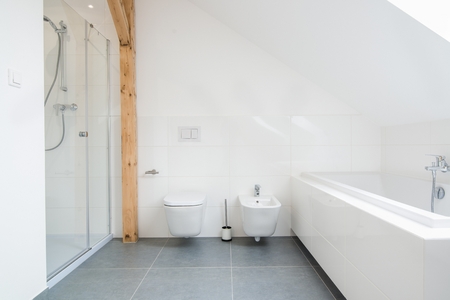 White loft bathroom with glass shower cabin. Modern bright flat apartment in the attic.