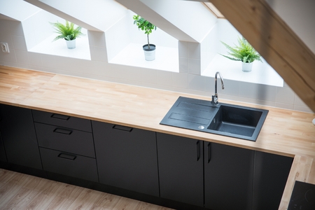 Black sink in the kitchen. Modern kitchen in the attic with black kitchen cabinetsの写真素材