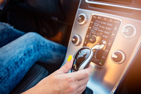 Woman changing modes in automatic gearbox. Woman driving a carの写真素材