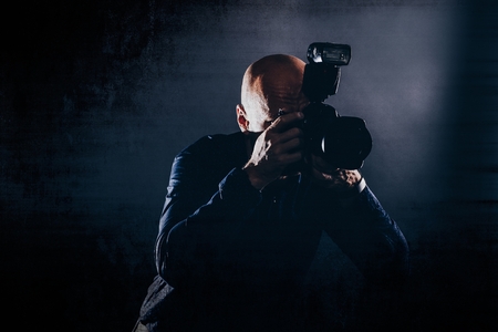 Photographer with dslr camera. Man photographer portrait in studio.の写真素材