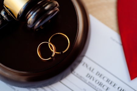 Two broken golden wedding rings on judge gavel. Divorce and separation conceptの写真素材