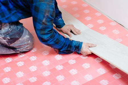 Worker installing laminate floor panels. Home improvement and renovation conceptの写真素材