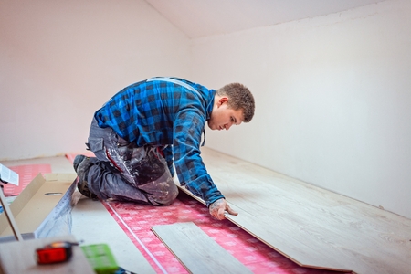 Worker installing laminate floor panels. Home improvement and renovation conceptの写真素材