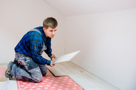 Worker installing laminate flooring panels. Home improvement and renovation conceptの写真素材