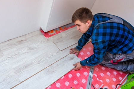 Worker installing laminate floor panels. Home improvement and renovation conceptの写真素材