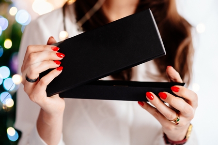 Happy excited beautiful young woman opening jewelry gift box. Christmas giftの写真素材