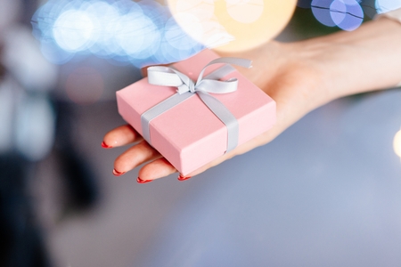 Woman holding present in hand. Christmas surpriseの写真素材