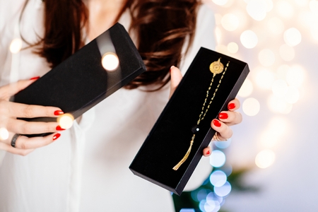 Young attractive woman opening black present box with necklace. Christmas surpriseの写真素材