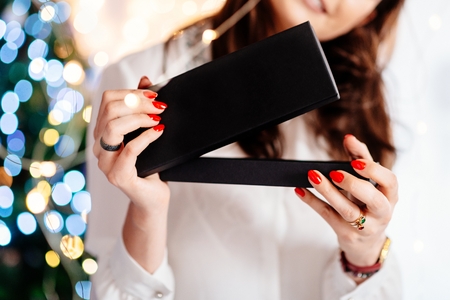 Happy excited beautiful young woman opening jewelry gift box. Christmas giftの写真素材