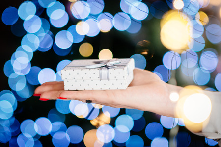 Close up on young woman hand giving Christmas present. Christmas giftの写真素材