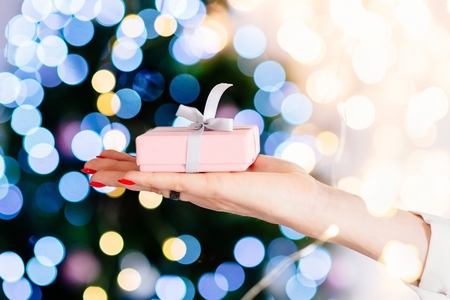 Woman holding present in hand. Christmas surpriseの写真素材