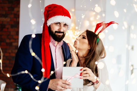 Happy couple with Christmas surprise gift. Man and woman at christmasの写真素材