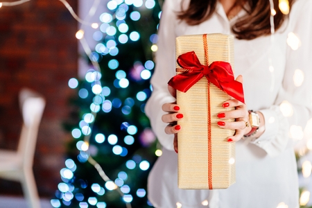 Close up on woman hands giving Christmas present. Christmas giftの写真素材