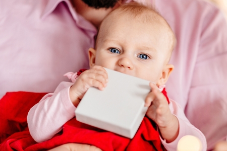 Baby girl holding gift box. Christmas giftの写真素材