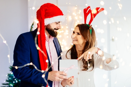 Happy couple with Christmas gift. Man and woman at christmasの写真素材