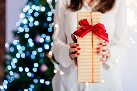 Close up on woman hands giving Christmas present. Christmas giftの写真素材