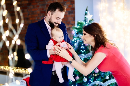 Mother giving Christmas present to her baby child. Family at Christmas. Christmas surprise. Merry Christmas!の写真素材