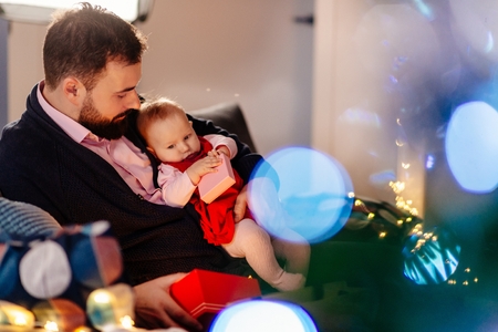 Alone father giving his baby Christmas present. Christmas surprise. Merry Christmas!の写真素材