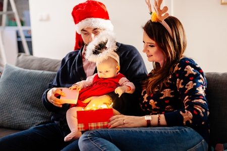 Baby first Christmas present. Family at Christmas. Christmas surprise. Merry Christmas!の写真素材