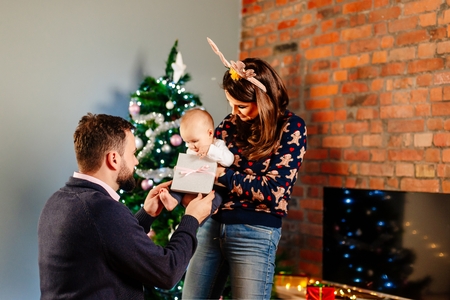 Young parents with their baby at Christmas. Family at Christmas. Merry Christmas!の写真素材