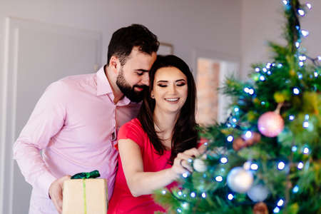 Happy couple decorating Christmas tree. Merry Christmas!の写真素材