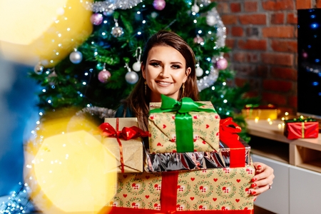 Happy young woman holding Christmas present. Woman at Christmas. Christmas surprise.の写真素材