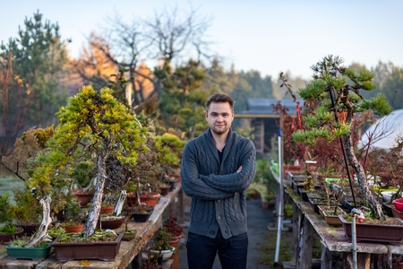 Young man bonsai artist in his bonsai farm. Small business conceptの写真素材