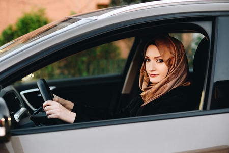 Muslim woman in car as driver. Arabic woman in hijab driving a carの写真素材